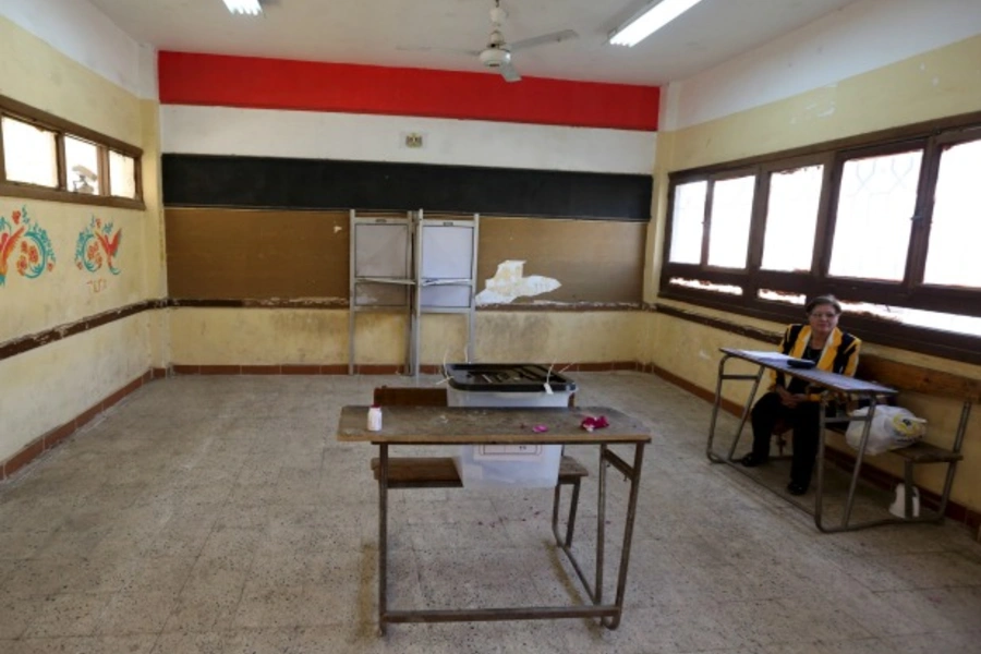 An election monitor sits near a ballot box at a polling station while waiting for voters during the second phase of the parliamentary election runoff at the Shubra area of Cairo, Egypt (Reuters/Mohamed Abd El Ghany).