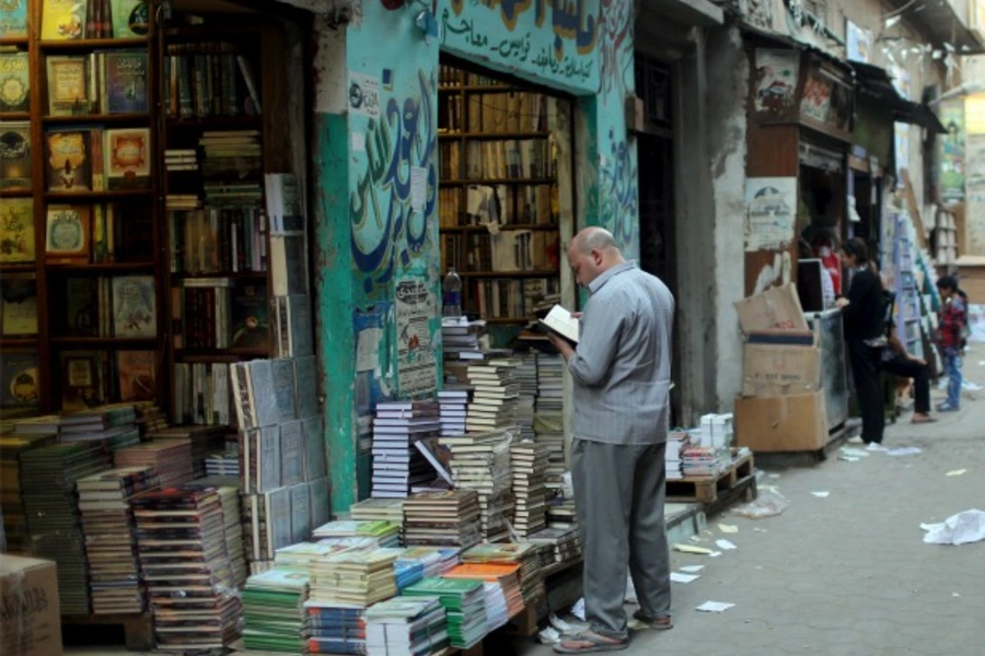 A man looks at a book outside of a bookshop that sells Islamic and reference books for Al-Azhar students near the Al-Azhar mosque in Cairo, Egypt, May 18, 2015 (Asmaa Waguih/Reuters).