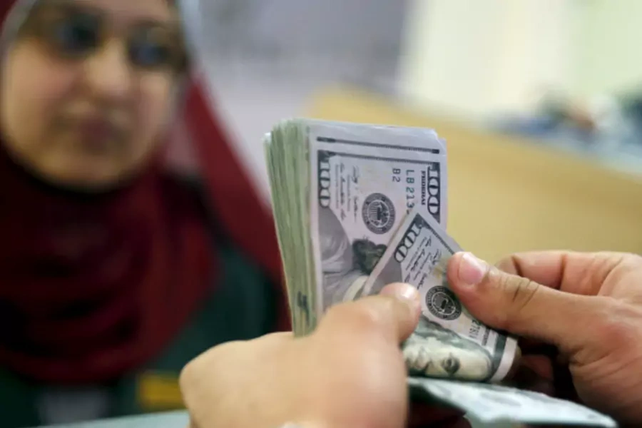 A customer counts his U.S. dollar money in a bank in Cairo, Egypt (Amr Abdallah Dalsh/Reuters).