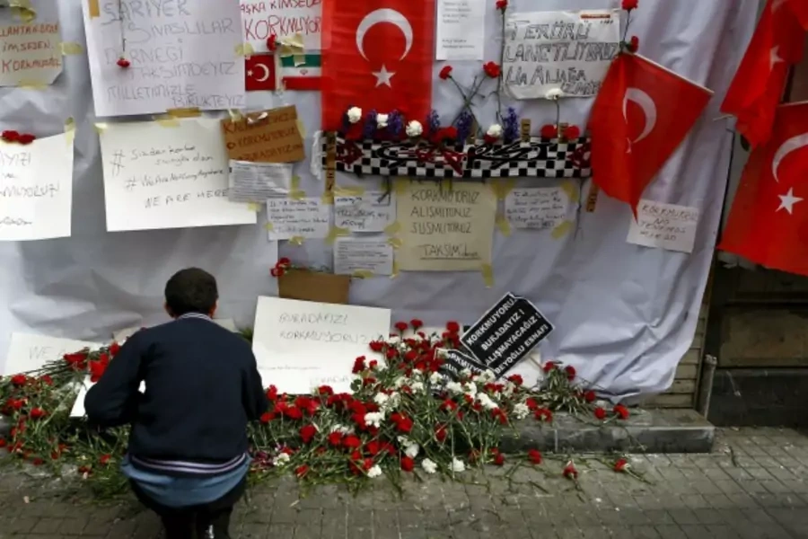 A man places carnations at the scene of a suicide bombing at Istiklal street, a major shopping and tourist district, in central Istanbul, Turkey (Osman Orsal/Reuters).