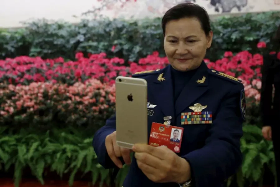A military delegate takes pictures with her iPhone ahead of the opening session of the Chinese People's Political Consultative Conference (CPPCC) at the Great Hall of the People in Beijing, China, March 3, 2016. (Kim Kyung-hoon/Reuters)