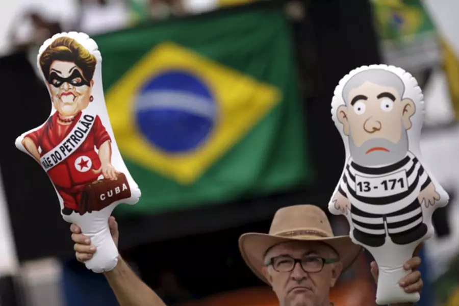 A demonstrator holds inflatable dolls depicting Brazil's former president Luiz Inacio Lula da Silva (R) and Brazil's President... for the impeachment of Rousseff near the National Congress in Brasilia, Brazil, December 13, 2015 (Ueslei Marcelino/Reuters).