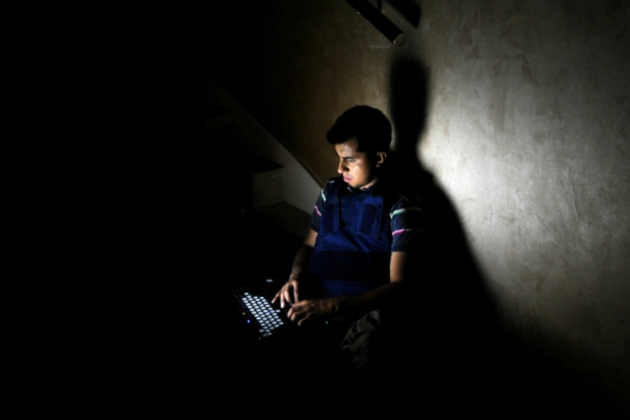 A member of the media works on a staircase at the Rixos hotel during a power cut in Tripoli (Paul Hackett/Reuters).