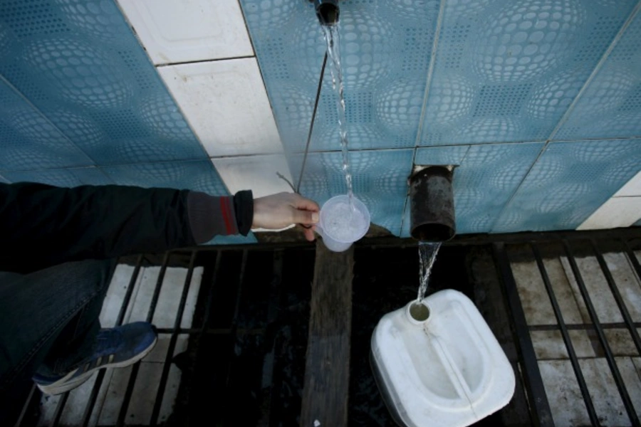 A man fills a glass with water from a spring in Chiffa in Medea Governorate, Algeria (Reuters/Ramzi Boudina).