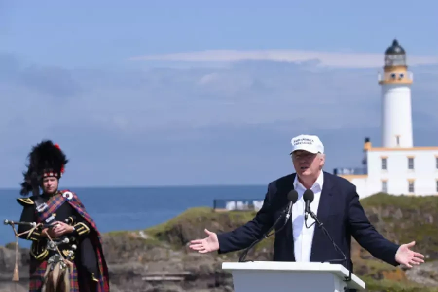 Presumptive Republican presidential candidate Donald Trump speaks during a news conference, as he is watched by a piper in front of the lighthouse, at his Turnberry golf course in Scotland on June 24, 2016.
