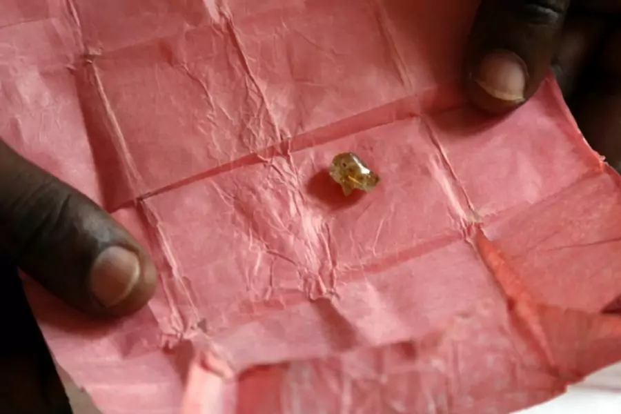 A man displays a rough diamond, from the Boda region, for sale in Bangui May 1, 2014. Despite a 2013 ban on diamond exports by... in "blood diamonds", rough diamonds are still commonly offered for sale in Central African Republic (Reuters/Emmanuel Braun).