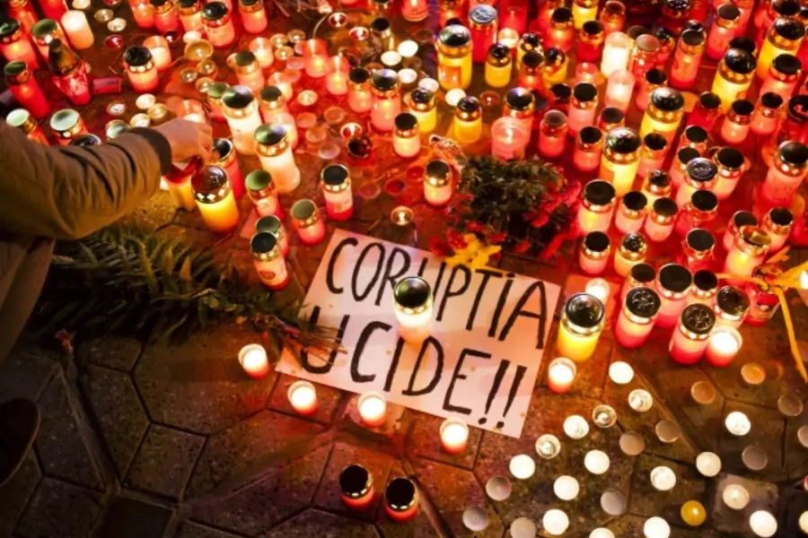 A banner reading "Corruption kills" is placed among candles, lit in memoriam of more than 50 people killed when a fire erupted...e died reflect growing anger at a culture of official graft in one of Europe's most corrupt countries (Reuters/Inquam Photos).