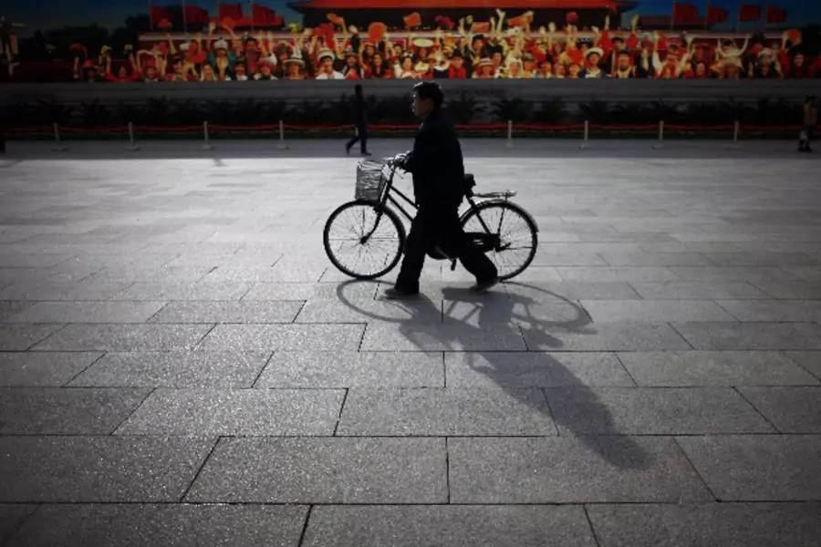 A man walks with his bicycle in front of a screen showing propaganda displays near the Great Hall of the People at Beijing's T... Vice President Xi Jinping at the congress, which starts on Thursday. REUTERS/Carlos Barria (CHINA - Tags: POLITICS ELECTIONS)
