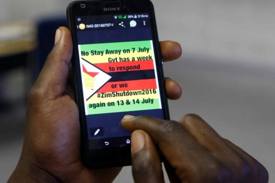 A man checks a message on his mobile phone, in Harare, Zimbabwe, July 7, 2016 (Reuters/Philimon Bulawayo).