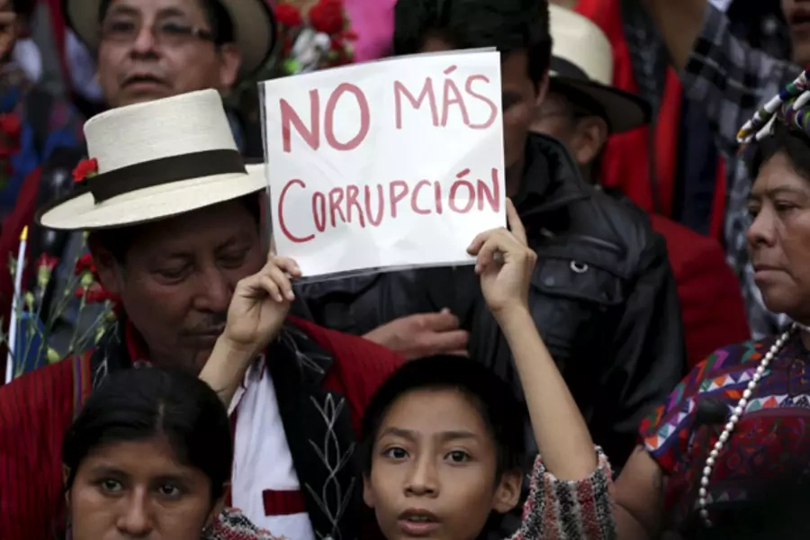 A boy holds a sign which reads, "No more corruption" during a demonstration demanding the resignation of Guatemalan President Otto Perez Molina, in downtown Guatemala City, May 30, 2015 (Reuters/Jorge Dan Lopez).