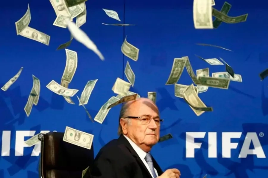 British comedian known as Lee Nelson (unseen) throws banknotes at FIFA President Sepp Blatter as he arrives for a news confere...p Blatter, at a special congress to be held on February 26 in Zurich, the organisation said on Monday (Reuters/Arnd Wiegmann).