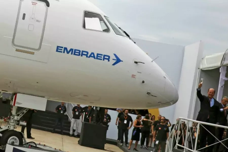 Brazilian aircraft maker Embraer's CEO Frederico Curado (R) salutes workers next to an new Embraer E190-E2 during its unveil i...ation, following the end of international sanctions, Chief Executive Curado told journalists on Thursday (Reuters/Nacho Doce).