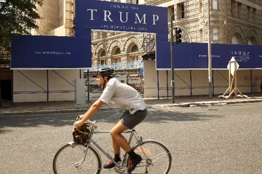 A cyclist passes the construction entrance to the Trump International Hotel in Washington September 1, 2015. The iconic Old Post Office building is being transformed into a luxury hotel by presidential hopeful Donald Trump. REUTERS/Kevin Lamarque