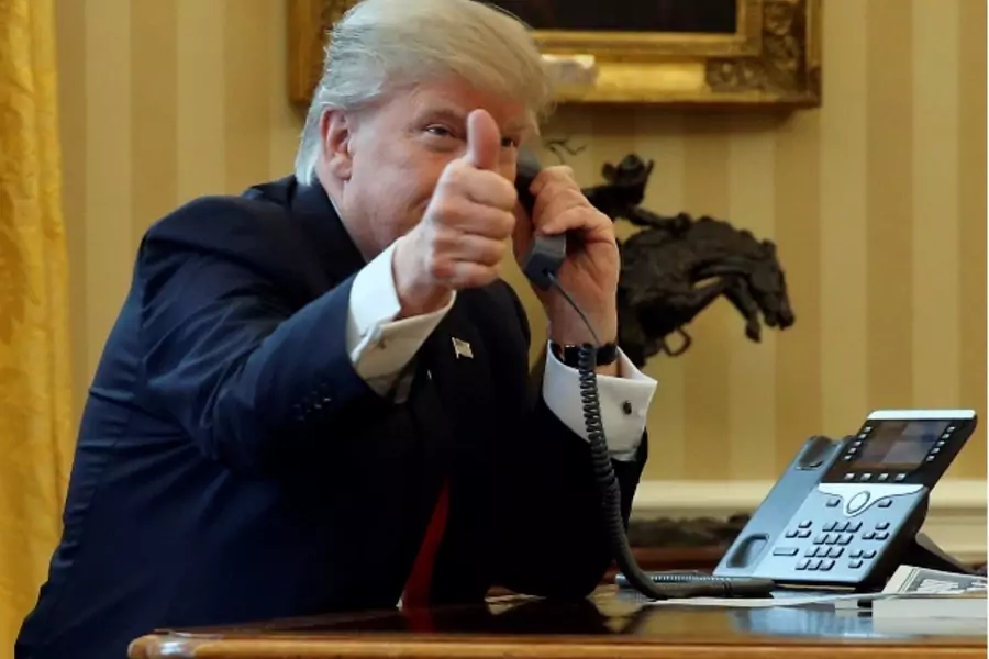 U.S. President Donald Trump gives a thumbs-up to reporters as he waits to speak by phone with the Saudi Arabia's King Salman in the Oval Office at the White House in Washington, U.S. January 29, 2017. REUTERS/Jonathan Ernst