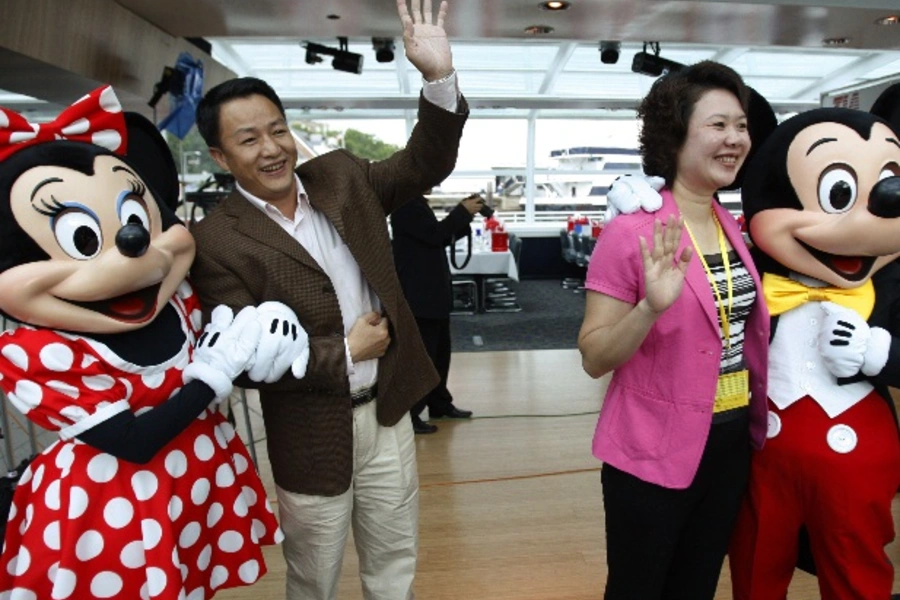 Tourists from China pose for a picture with Disney characters Mickey (R) and Minnie Mouse during a cruise for the first offici...l visitors from China to the United States, according to industry and government forecasts. REUTERS/Jason Reed (UNITED STATES)