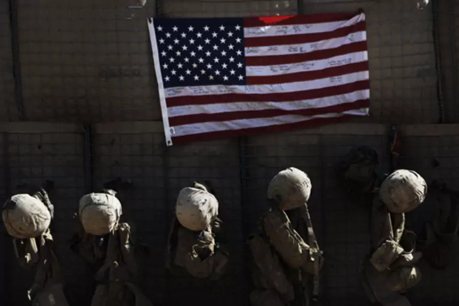 Equipment belonging to U.S. Marines hang by a flag at their outpost in Afghanistan's Helmand province. (Finbarr O'Reilly/courtesy Reuters)
