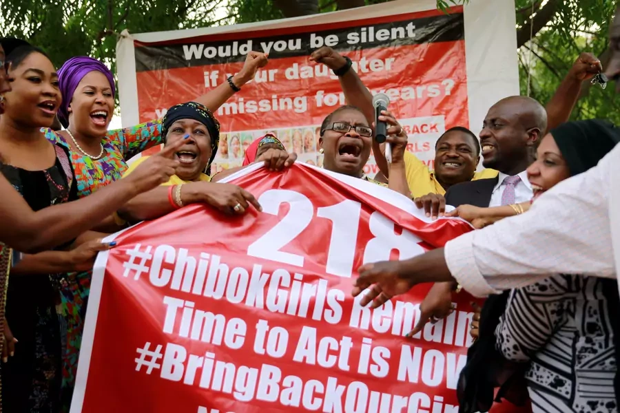 Members of the #BringBackOurGirls (#BBOG) campaign react on the presentation of a banner which shows "218", instead of the previous "219", referring to kidnapped Chibok school girls, during a sit-out in Abuja, Nigeria May 18, 2016.