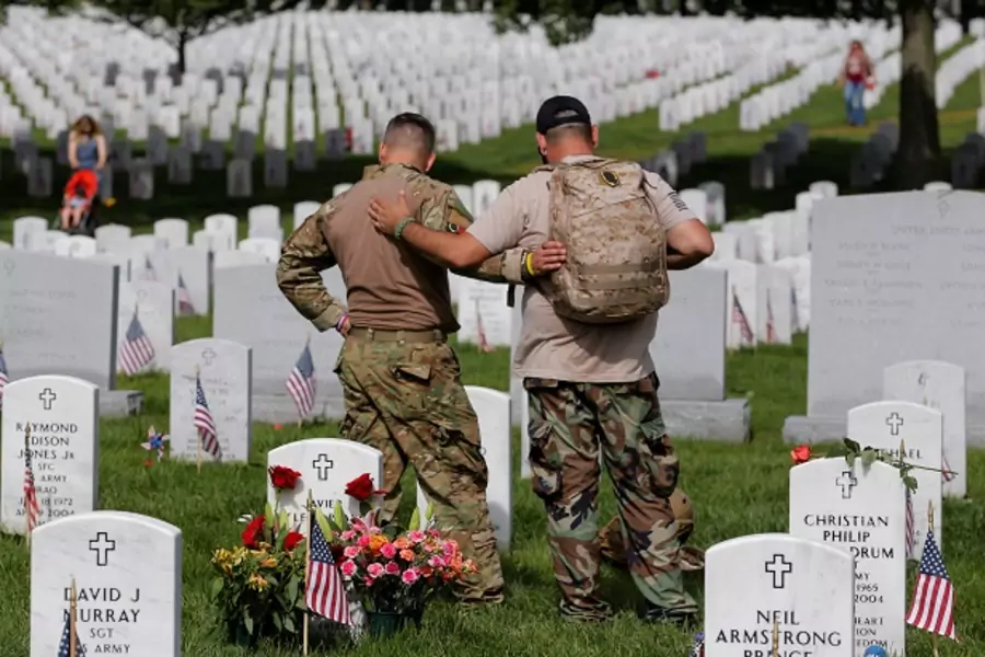 U.S. Army soldiers visit the grave of a fallen friend at Arlington National Cemetery 