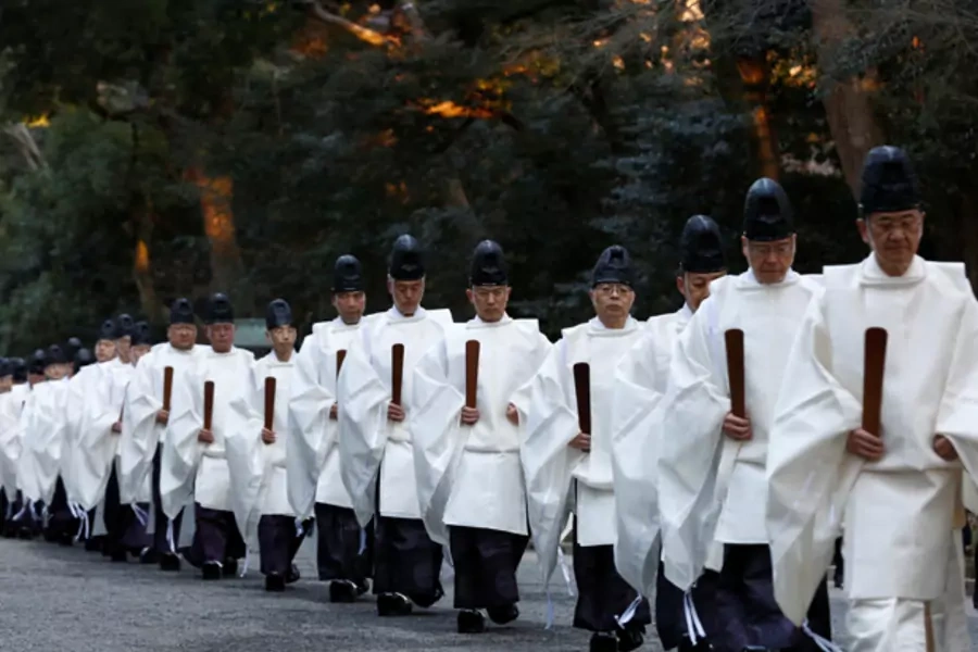 Shinto priests walk in a line to attend a ritual to usher in the upcoming New Year at the Meiji Shrine in Tokyo, Japan on December 31, 2016.