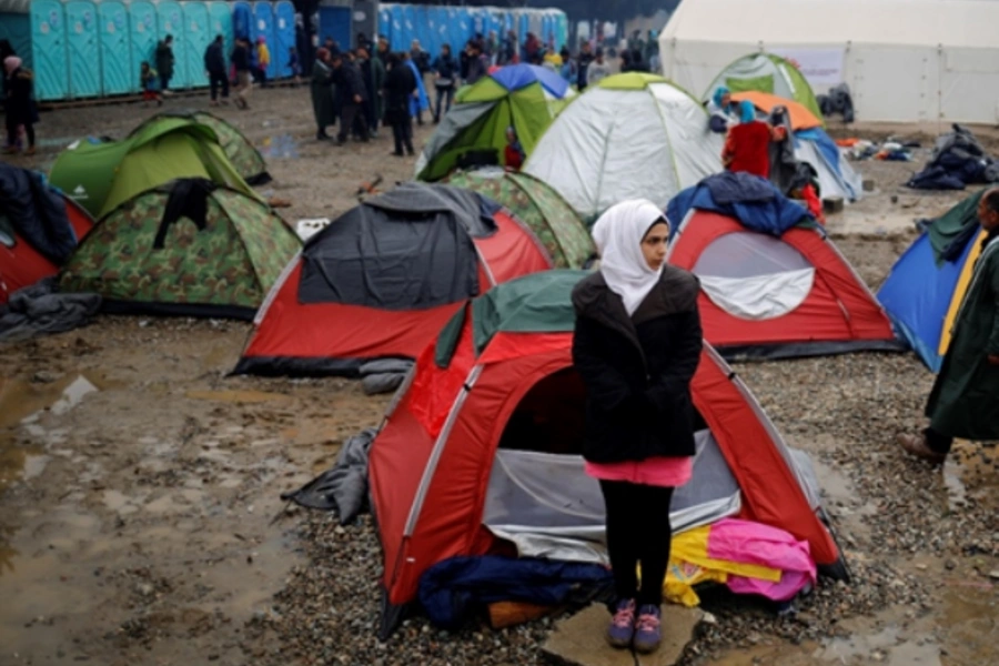 A migrant woman stands outside a tent at a makeshift camp on the Greek-Macedonian border.