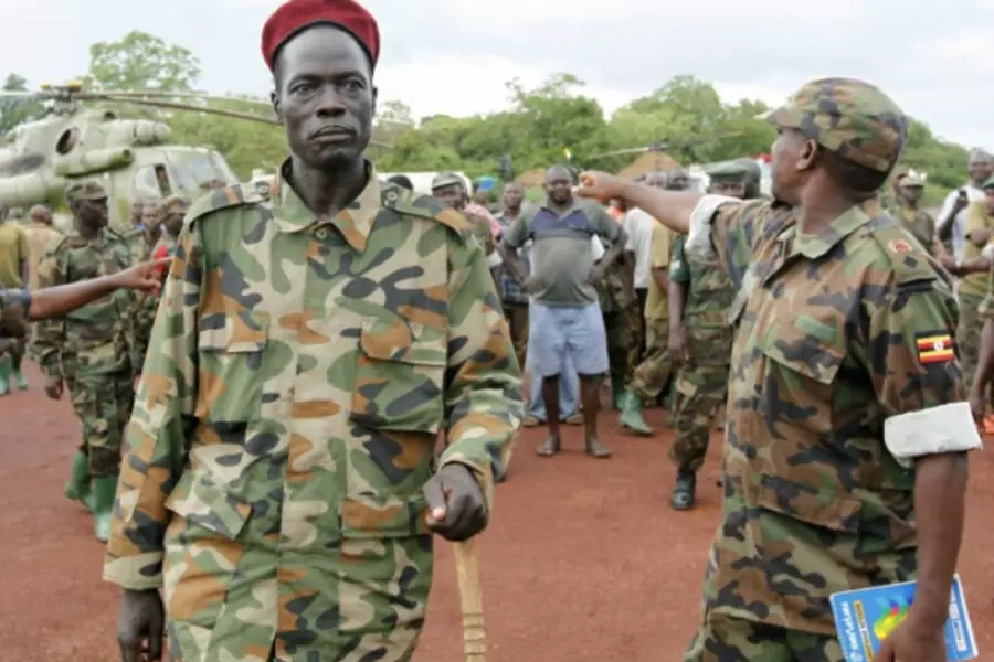 Lord's Resistance Army (LRA) commander Caesar Achellam (C) is escorted by members of the Ugandan army on arrival at the army operation base in Nera in South Sudan May 13, 2012, after he was captured by Ugandan soldiers tracking down LRA fugitive leaders.