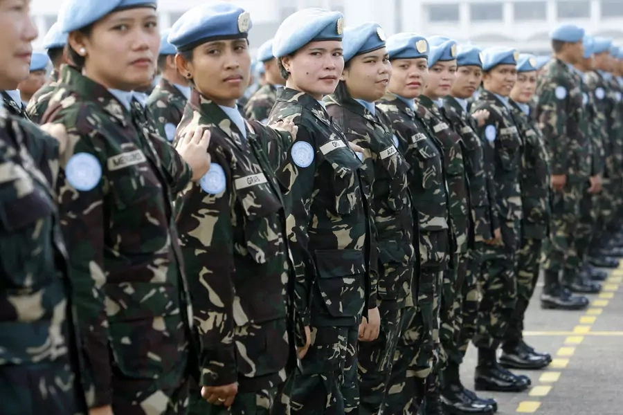 Female members of a Philippine peacekeeping force bound for Liberia stand at attention during a send-off ceremony at the military headquarters in Manila January 28, 2009.