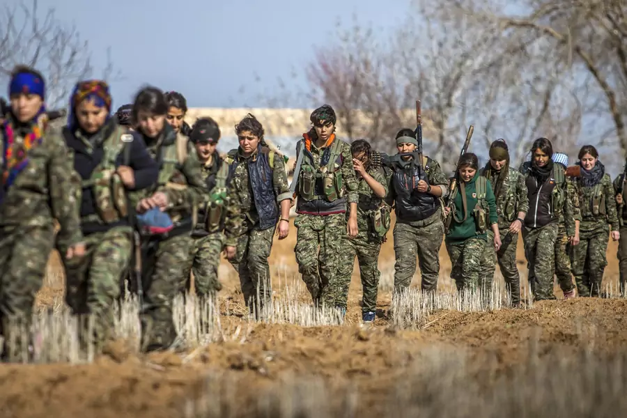 Female fighters of the Kurdish People's Protection Units (YPG) carry their weapons as they walk in the western countryside of Ras al-Ain January 25, 2015. 