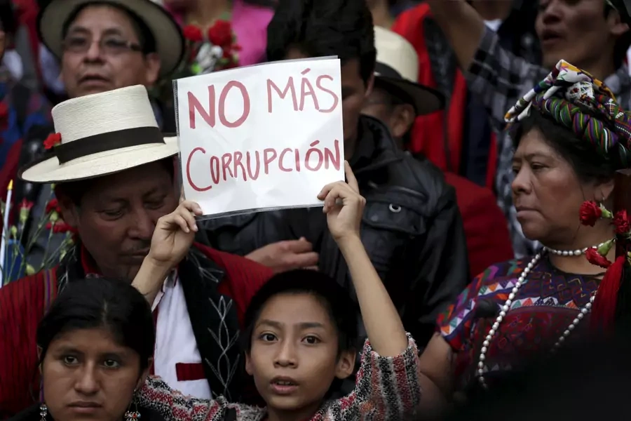 A boy holds a sign that reads “No more corruption” during a demonstration demanding the resignation of Guatemalan President Otto Perez Molina, in downtown Guatemala City, May 30, 2015.