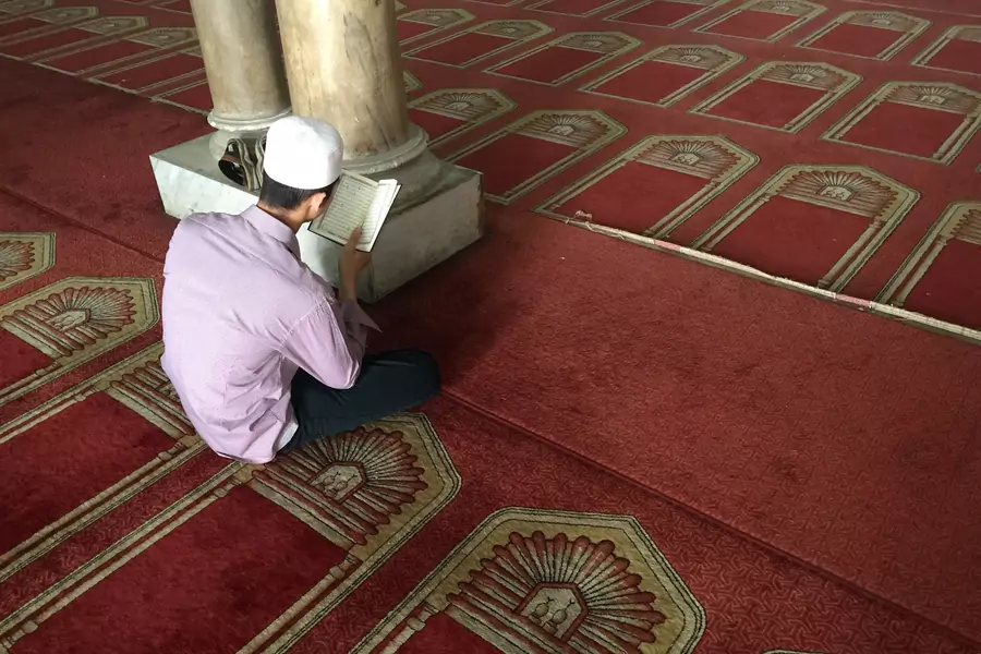 An Egyptian Muslim man reads the Quran in al-Azhar mosque as restoration work is conducted ahead of Pope Francis’ visit, in Cairo (Amr Abdallah Dalsh/Reuters).