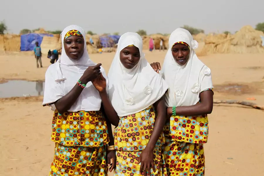 Adolescent girls pose for pictures at the Boudouri site for displaced persons outside the town of Diffa in southeastern Niger June 18, 2016. 