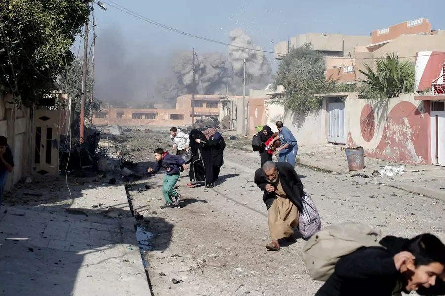 People run in panic after a coalition airstrike hit Islamic State fighters positions in Tahrir neighborhood of Mosul, Iraq, on November 17, 2016. 