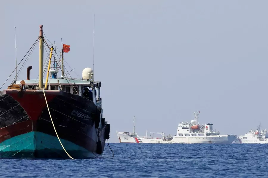 China Coast Guard vessels patrol past a Chinese fishing vessel at the disputed Scarborough Shoal, April 5, 2017. 