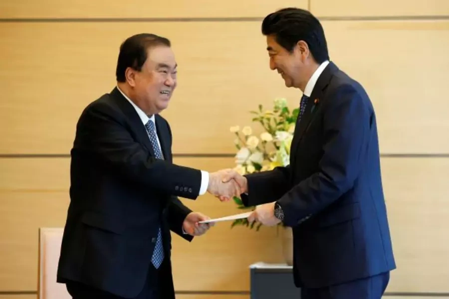 South Korean special presidential envoy Moon Hee-sang (L) shakes hands with Japan's Prime Minister Shinzo Abe as he hands a letter from South Korea's President Moon Jae-in to Abe at Abe's official residence in Tokyo, Japan, May 18, 2017(Reuters/Toru Hana)