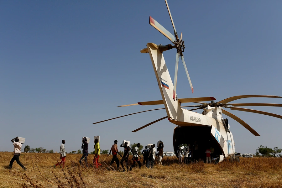 Men unload boxes of nutritional supplements from an helicopter prior to a humanitarian food distribution carried out by the United Nations World Food Programme (WFP) in Thonyor, Leer county, South Sudan, February 25, 2017.