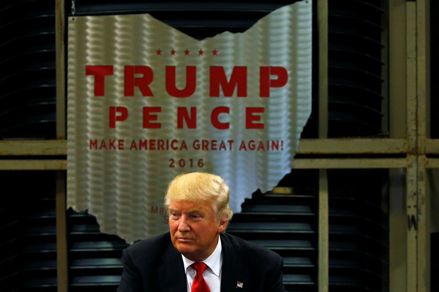 Donald Trump sits beneath a steel emblem in the shape of the state of Ohio as he holds a business roundtable at the Staub Manufacturing plant in Dayton, Ohio.