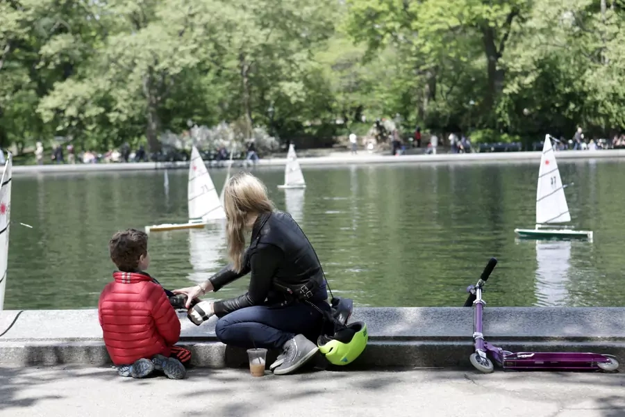 A woman and a child look at miniature sailboats on Mother's Day in Central Park, New York City, U.S., May 14, 2017. 