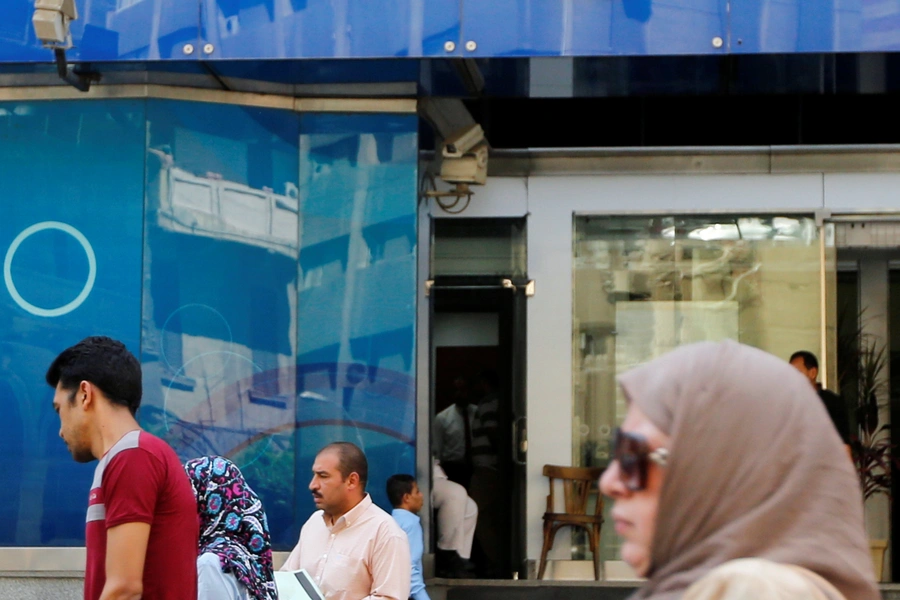 People walk in front of Arab Bank in downtown Cairo, Egypt July 25, 2017.