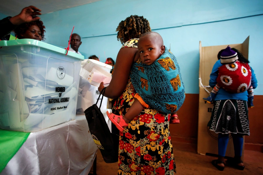 Women carrying babies cast their vote in Gatundu in Kiambu county, Kenya August 8, 2017. Kiambu is one of Kenya's twenty-one counties where more women than men are registered to vote.