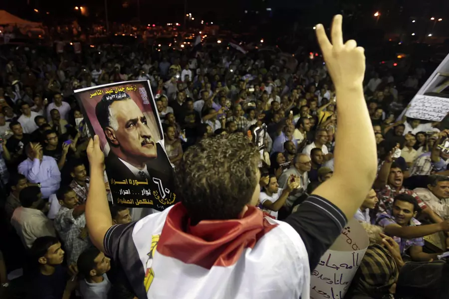 A protester holds up a poster with an image of former Egypt president Gamal Abdel Nasser during the anniversary of the 1952 Egyptian revolution at Tahrir Square in Cairo (Mohamed Abd El Ghany/Reuters).