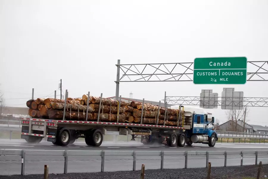 A truck carrying logs heads toward the Canada border in Champlain, New York.