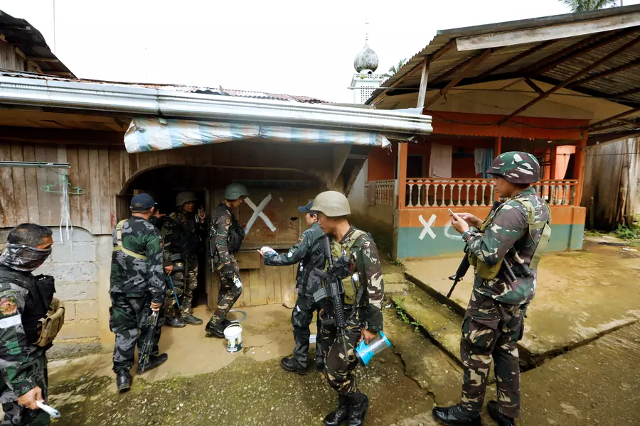 Members of the Philippine National Police (PNP) mark a house after clearing it as government troops continue their assault against insurgents from the Maute group in Marawi city on June 29, 2017.