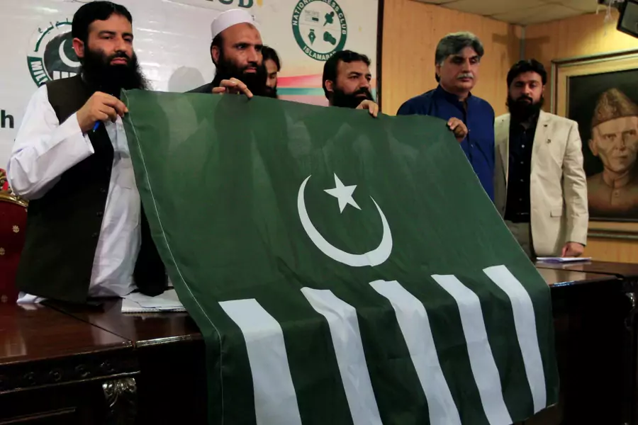 Saifullah Khalid (2nd L), president of the Milli Muslim League political party, holds a party flag with others during a news conference in Islamabad, Pakistan, August 7, 2017. 