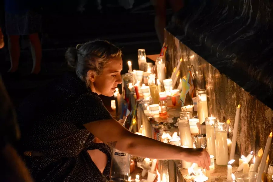 A woman places a candle at a vigil for Heather Heyer at the University of Virginia. 