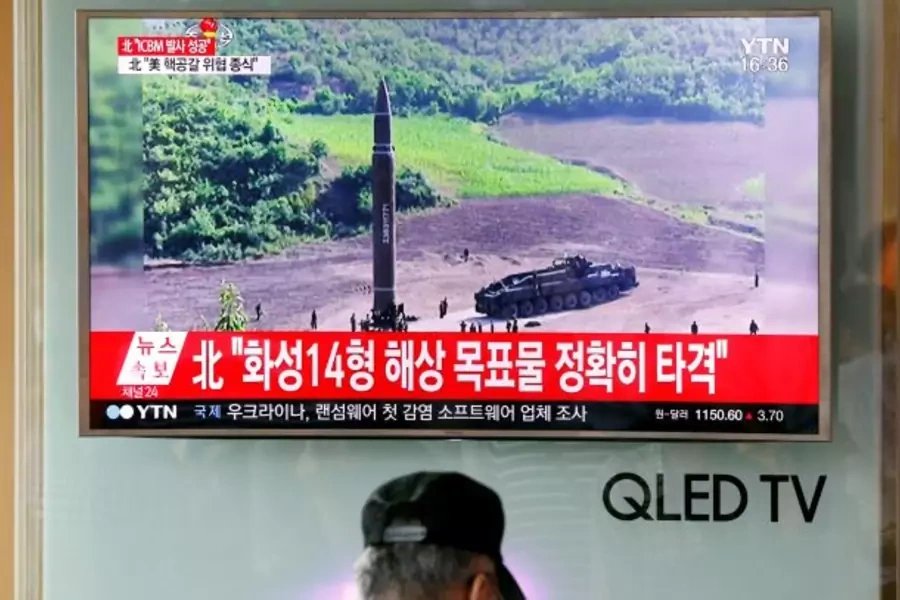 A man watches a TV broadcasting still photographs released by North Korea's state-run television KRT of North Korea's Hwasong-14 missile, a new intercontinental ballistic missile, which they said was successfully tested, at a railway station in Korea.