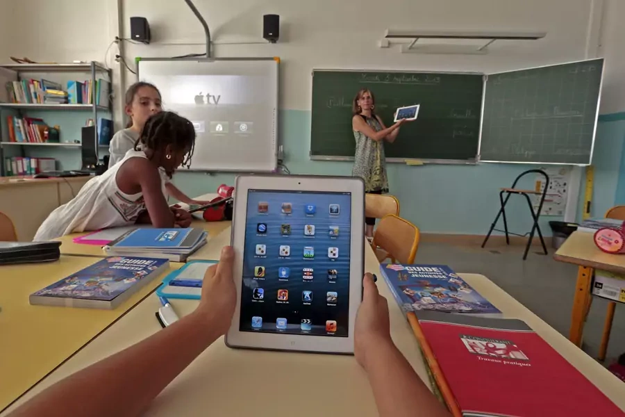 Elementary school children use electronic tablets on the first day of class in the new school year in Nice, September 3, 2013. 