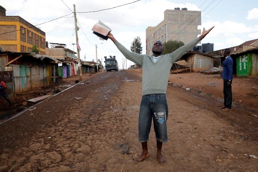 A protester shouts as a police vehicle approaches barricades in Kawangware slums in Nairobi, Kenya, the day after elections on October 27, 2017. Voting in a number of counties has been postponed due to violence and other disruptions.