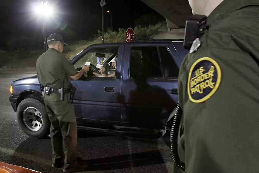 A U.S. Border Patrol agent checks the identification of a motorist at a checkpoint 20 miles north of the United States and Mexican border near Tubac, Arizona.