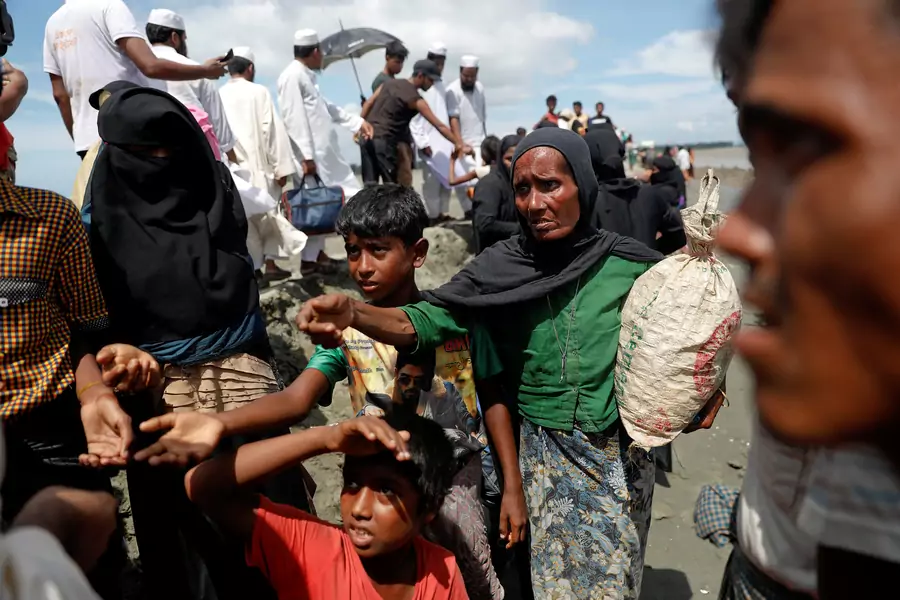 Rohingya refugees who just arrived by wooden boats from Myanmar reach out to receive some aid Teknaf, near Cox's Bazar in Bangladesh, October 3, 2017.
