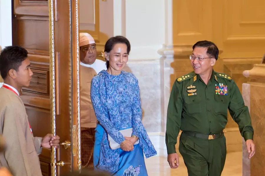 Aung San Suu Kyi (C) and Myanmar Military Chief Senior General Min Aung Hlaing arrive (R) for the handover ceremony from outgoing President Thein Sein and new Myanmar President Htin Kyaw at the presidential palace in Naypyitaw on March 30, 2016.