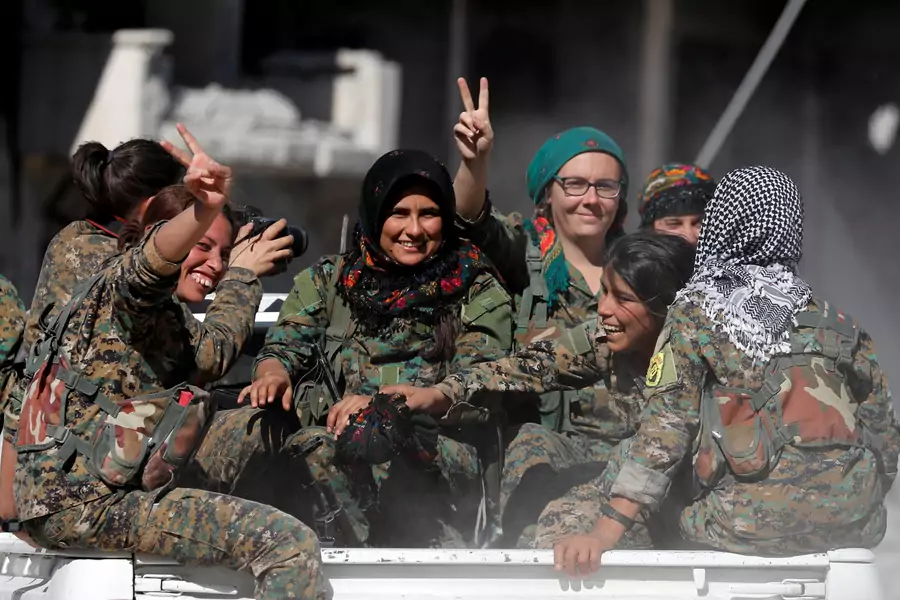 Female fighters of Syrian Democratic Forces gesture the "V" sign while onboard a pick up truck in Raqqa, Syria October 18, 2017. 